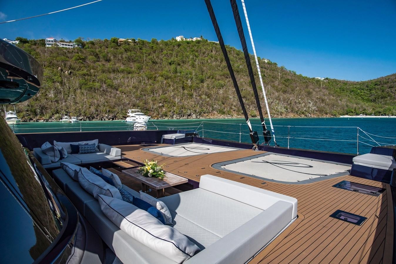 a deck with a pool and a hill in the background aboard 2022 SUNREEF 80 SAILING Yacht for Sale
