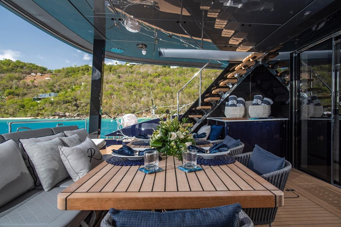 a patio with a table and chairs aboard 2022 SUNREEF 80 SAILING Yacht for Sale