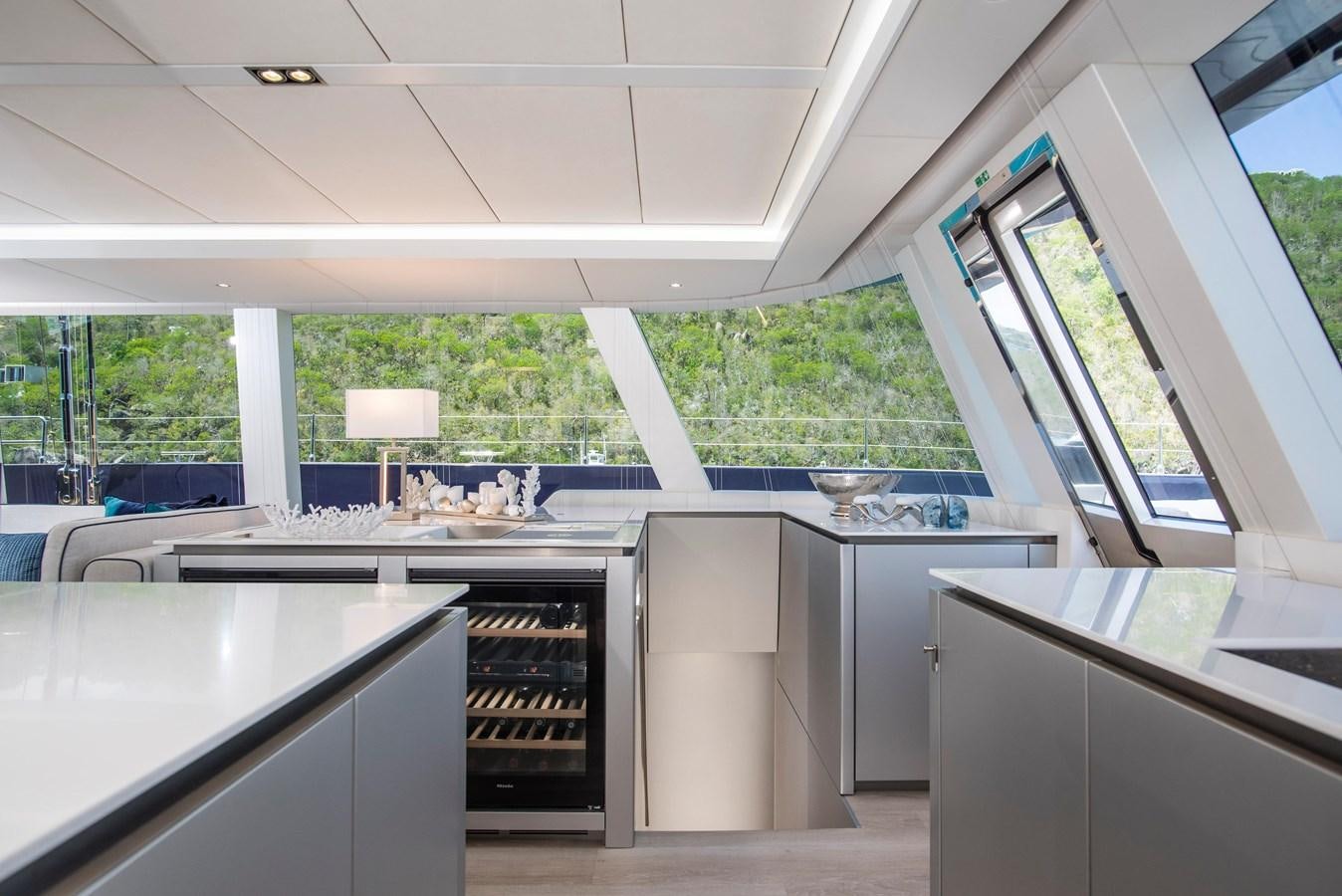 a kitchen with a large window aboard 2022 SUNREEF 80 SAILING Yacht for Sale