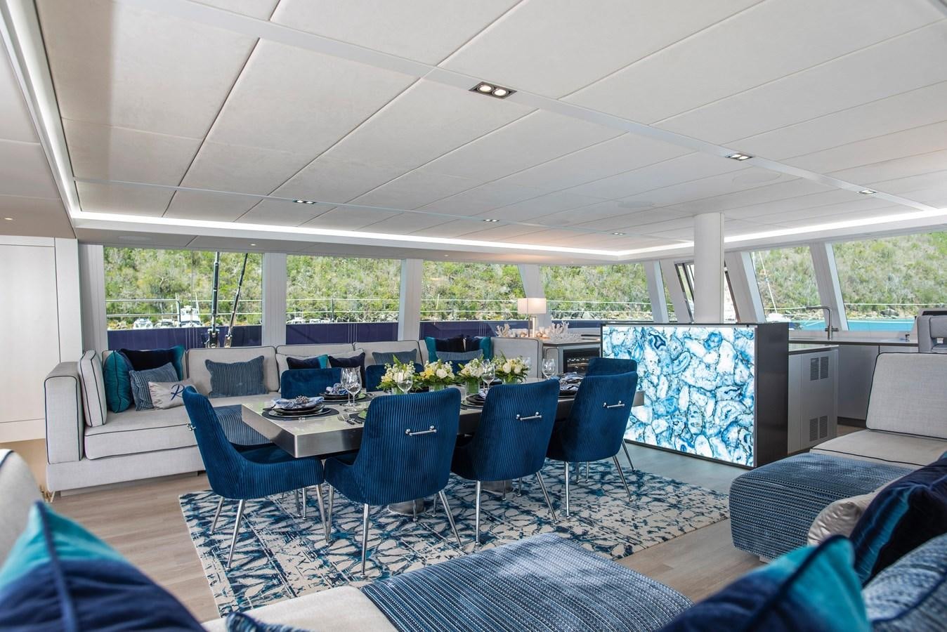 a room with a table chairs and a large window aboard 2022 SUNREEF 80 SAILING Yacht for Sale