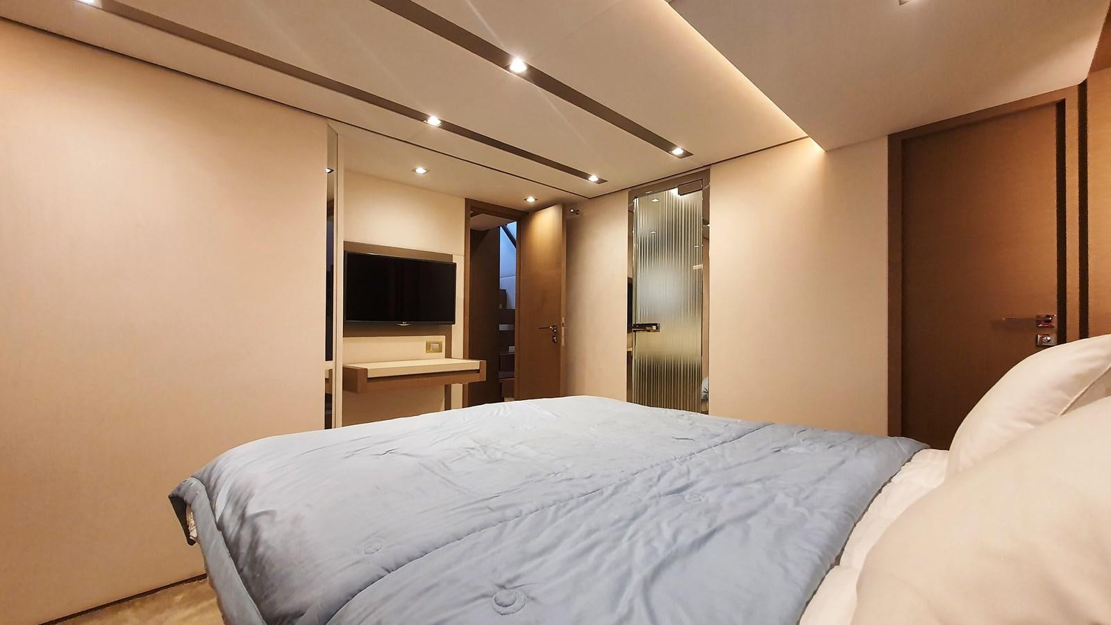 a bedroom with a bed and a television aboard NEW FISH Yacht for Sale