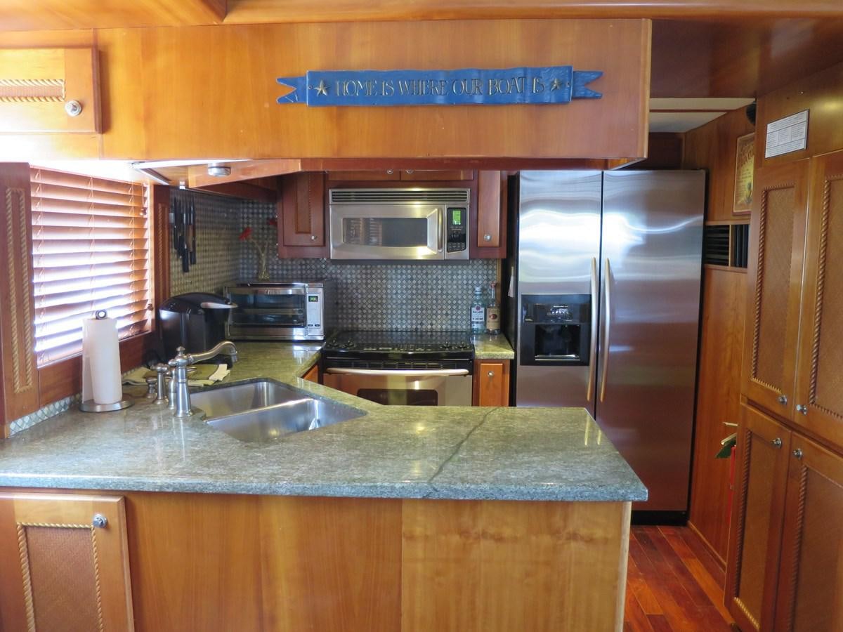 a kitchen with a stainless steel refrigerator aboard PATRICIA D Yacht for Sale