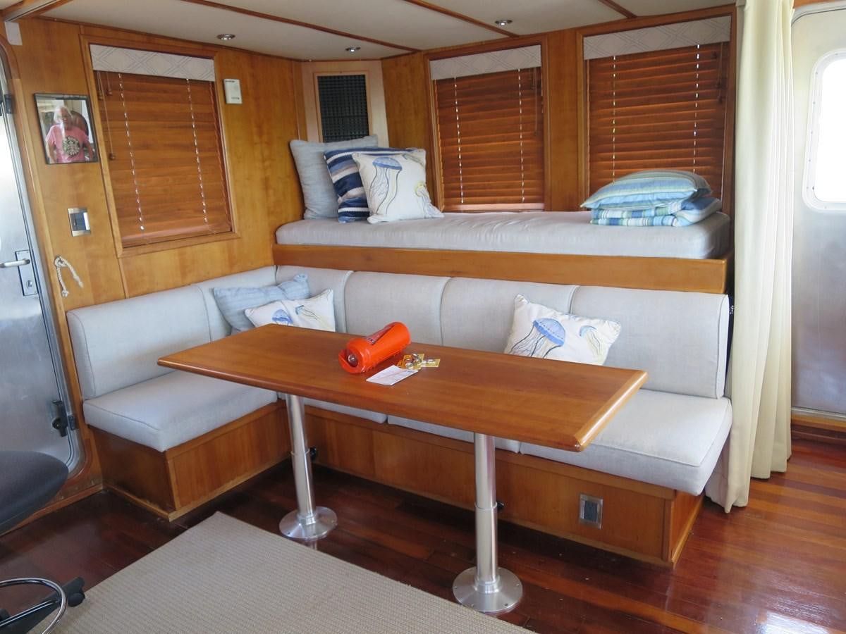 a bed and a table in a room aboard PATRICIA D Yacht for Sale