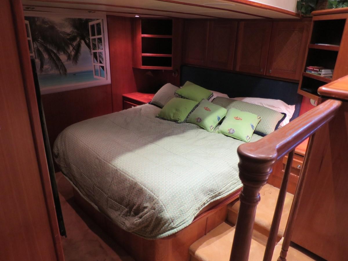 a bed with green pillows aboard PATRICIA D Yacht for Sale