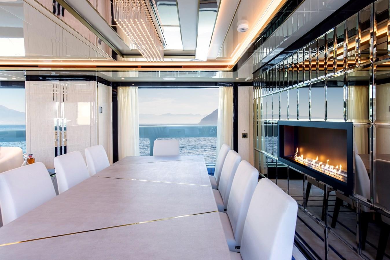 a room with a large table and chairs and a large fireplace aboard STEFANIA Yacht for Sale