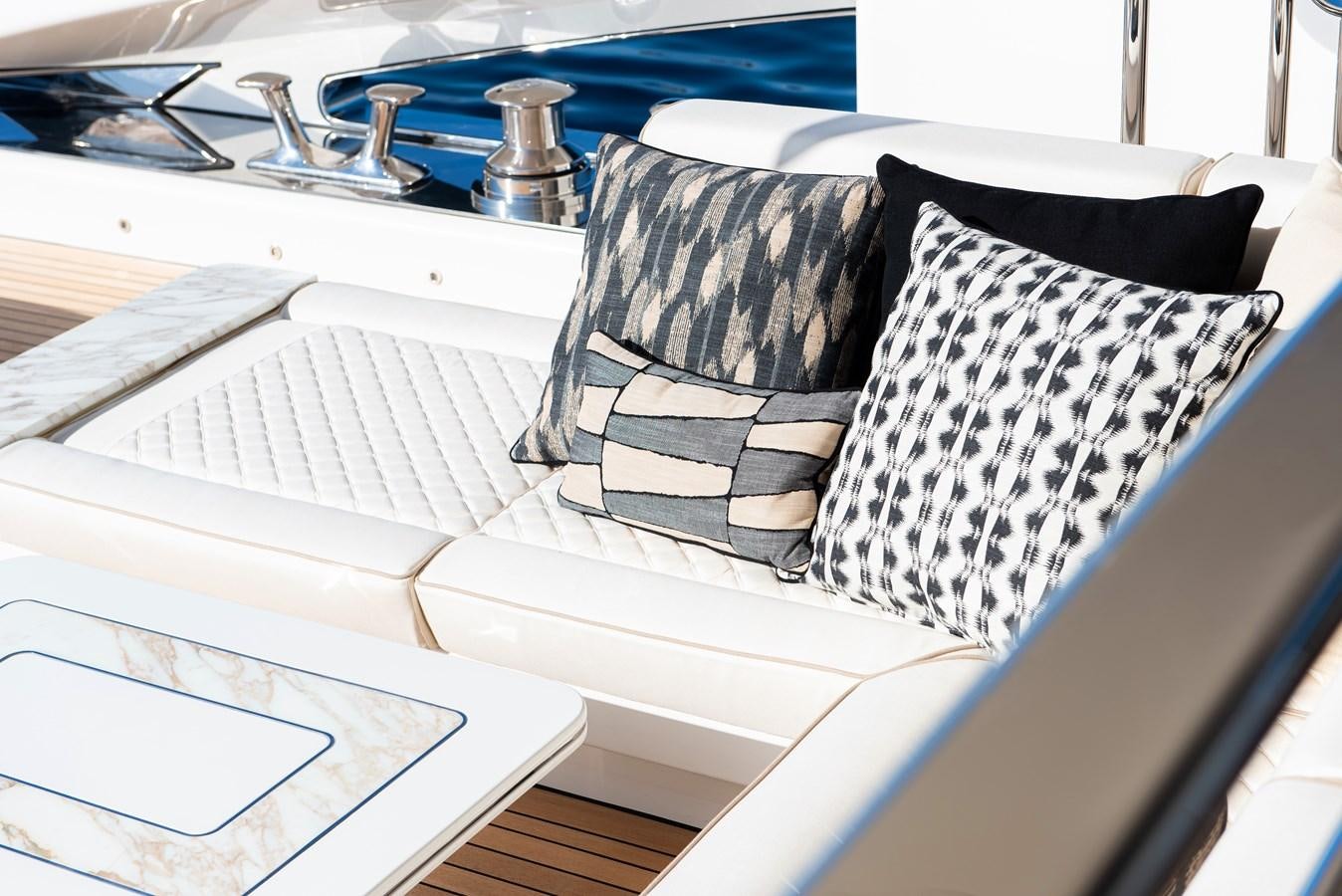 a black and white striped pillow on a white table aboard STEFANIA Yacht for Sale