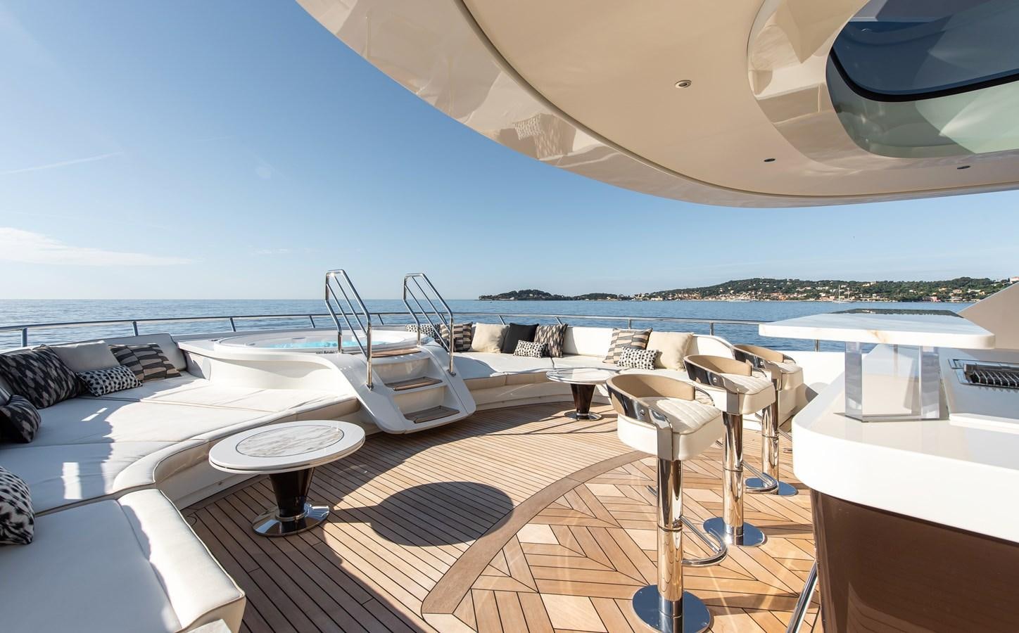 a room with a bed and a table and chairs on the deck aboard STEFANIA Yacht for Sale