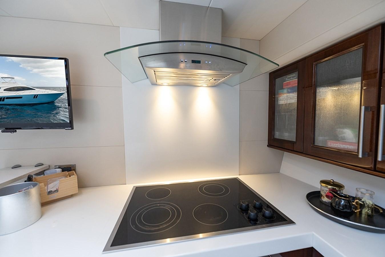 a kitchen with a stove and a light above it aboard LATITUDE Yacht for Sale