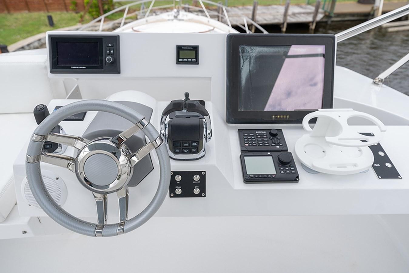 a white table with a black and silver console and a white screen aboard LATITUDE Yacht for Sale