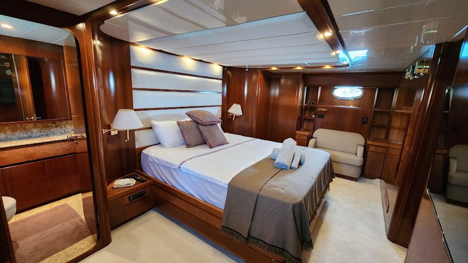 a room with a bed and a chair aboard THE ONE Yacht for Sale
