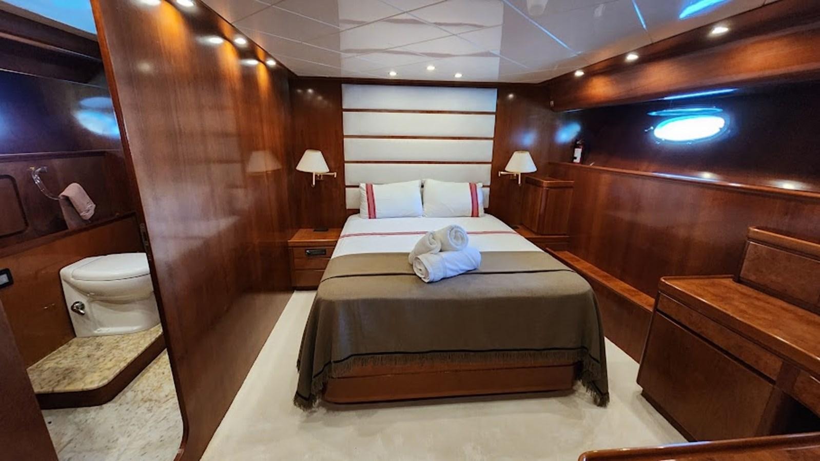 a room with a bed and a wood wall aboard THE ONE Yacht for Sale
