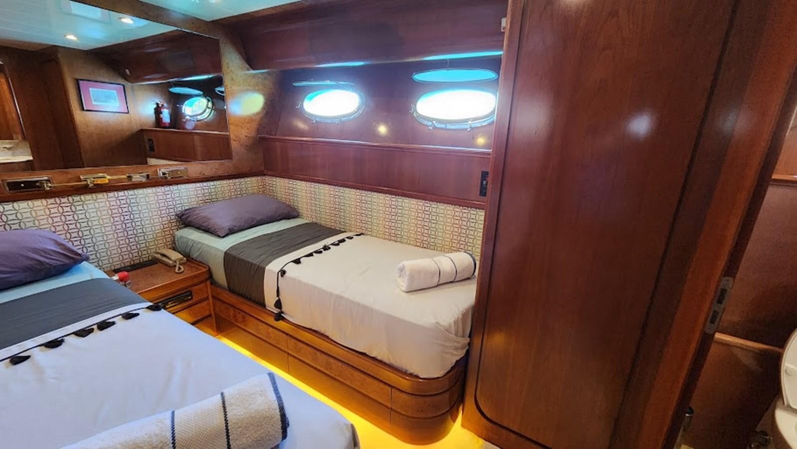 a room with beds and a window aboard THE ONE Yacht for Sale