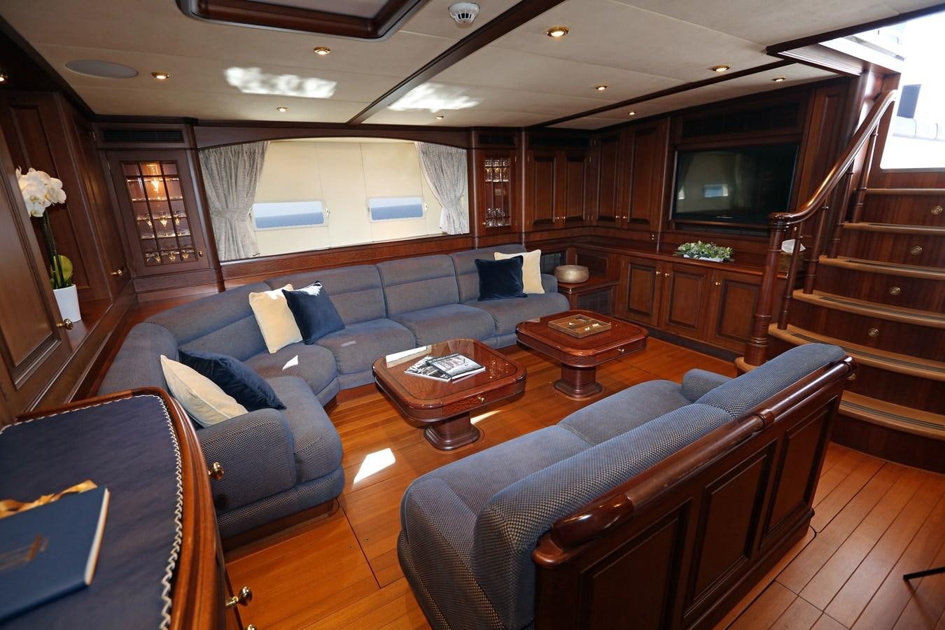a living room with a wood staircase aboard SOJANA Yacht for Sale