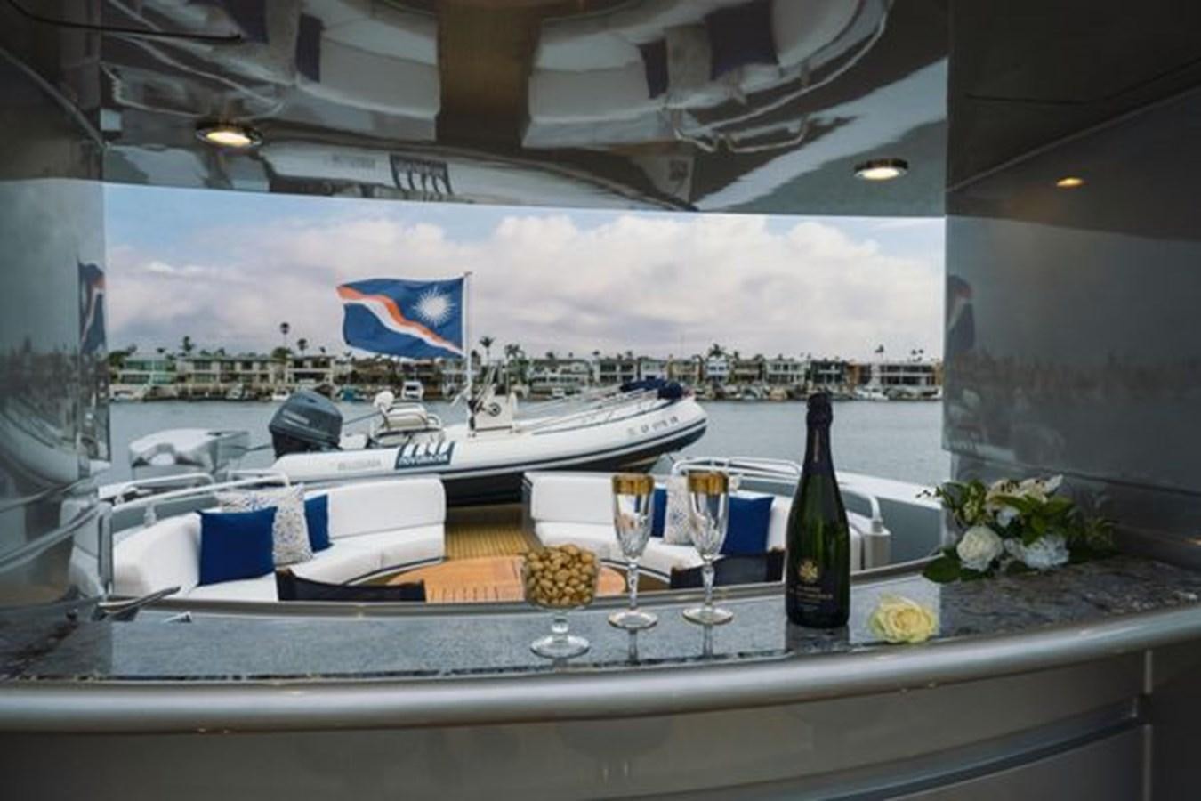 a glass bottle and a glass of wine on a table aboard 2003 BAGLIETTO 38M FAST FLY Yacht for Sale