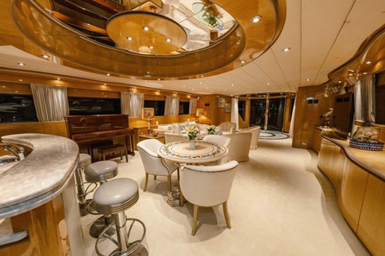 a large room with a piano and tables aboard 2003 BAGLIETTO 38M FAST FLY Yacht for Sale