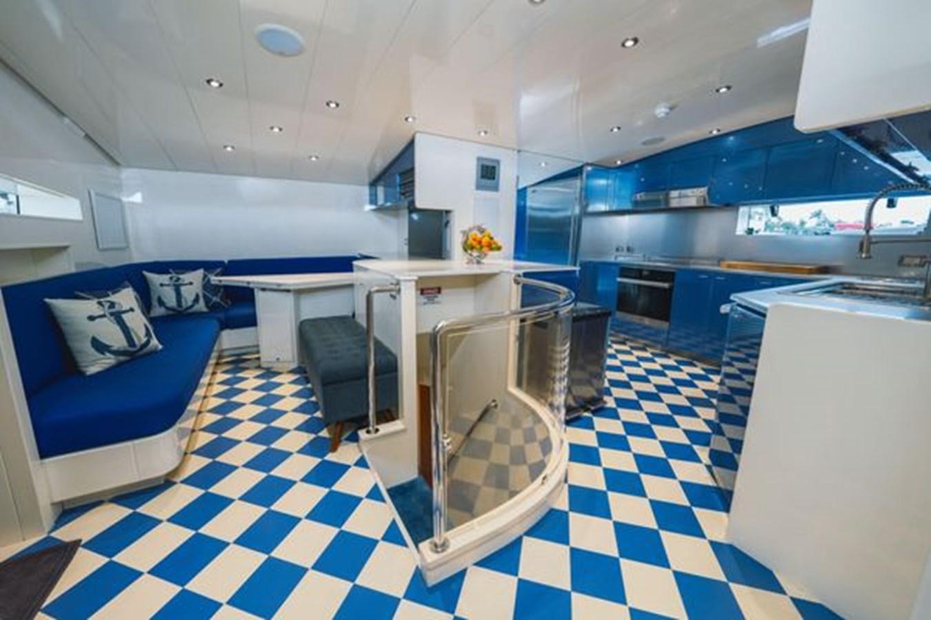 a large kitchen with a blue couch aboard 2003 BAGLIETTO 38M FAST FLY Yacht for Sale