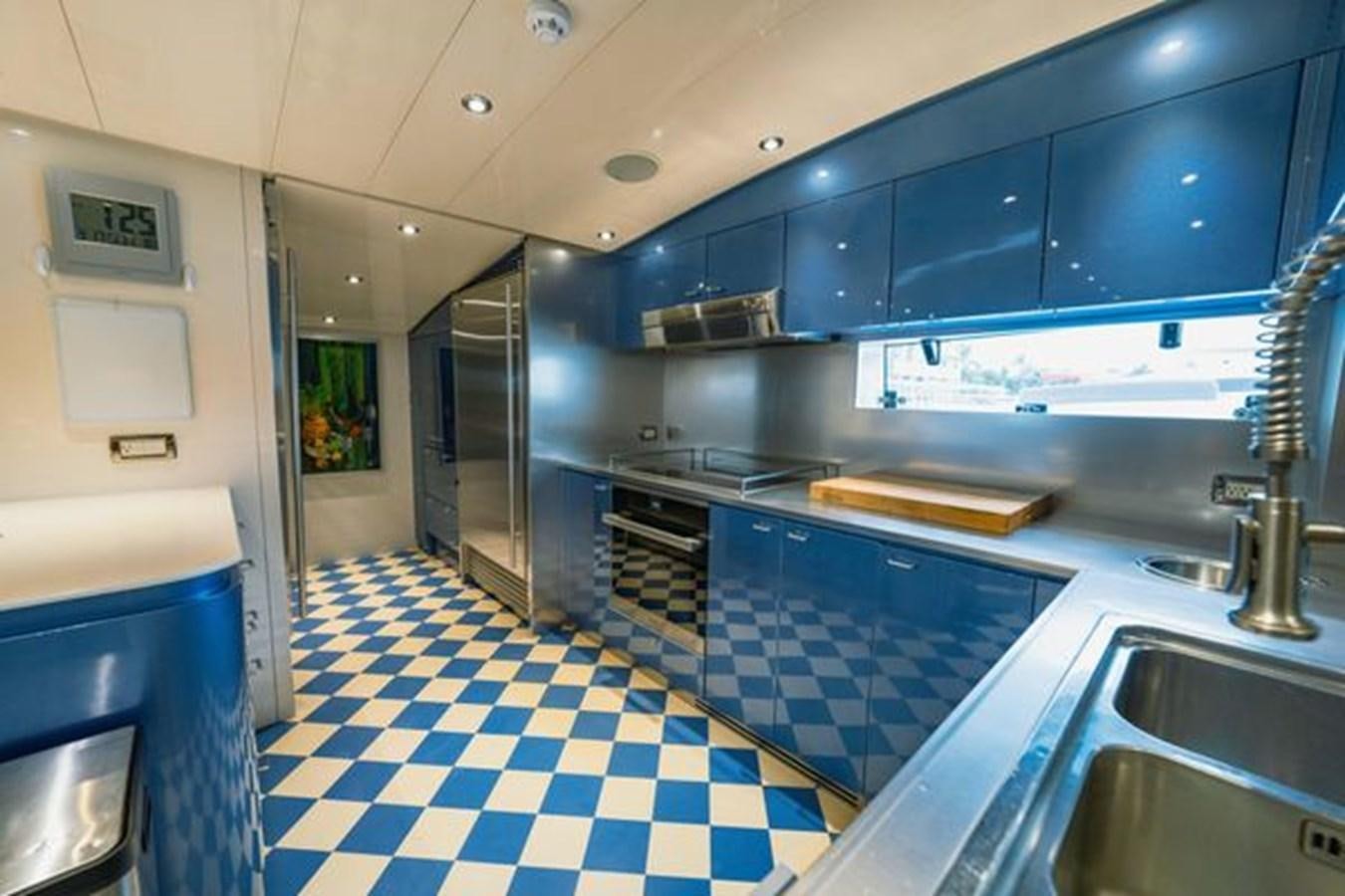 a kitchen with blue tile aboard 2003 BAGLIETTO 38M FAST FLY Yacht for Sale