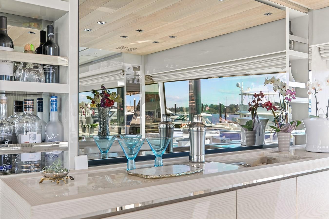 a kitchen with a lot of glass and a shelf with many vases of flowers aboard MISS LIZA Yacht for Sale