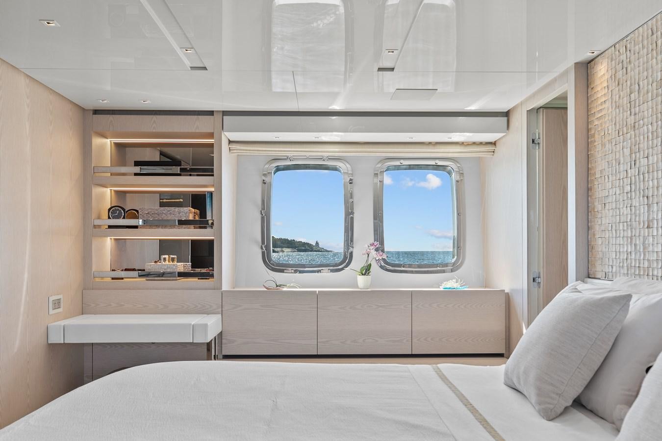 a room with a bed and a shelf with books on it aboard MISS LIZA Yacht for Sale