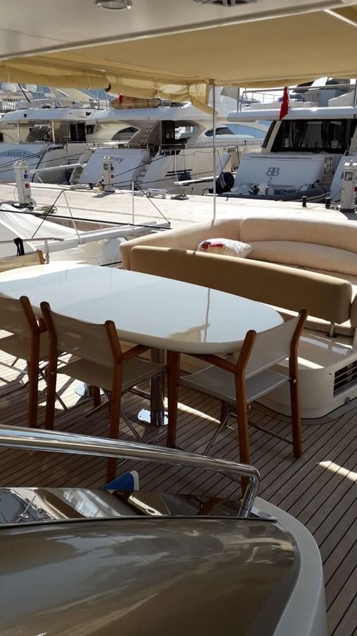 a row of tables and chairs in a room with a boat in the background aboard SLO Yacht for Sale