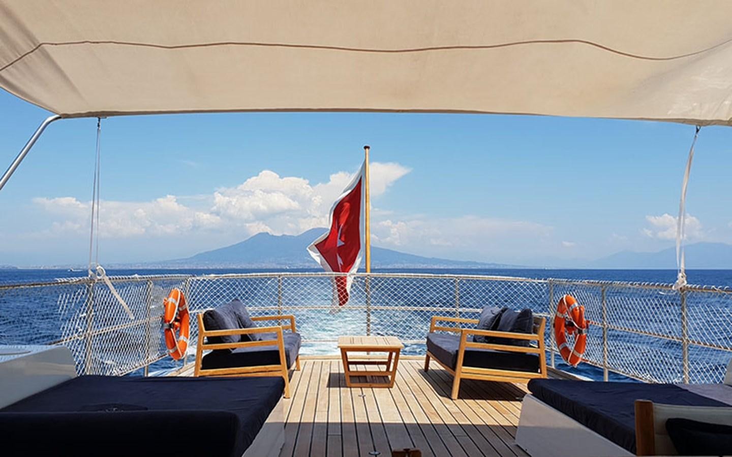 a boat with chairs and a flag aboard PERSUADER Yacht for Sale