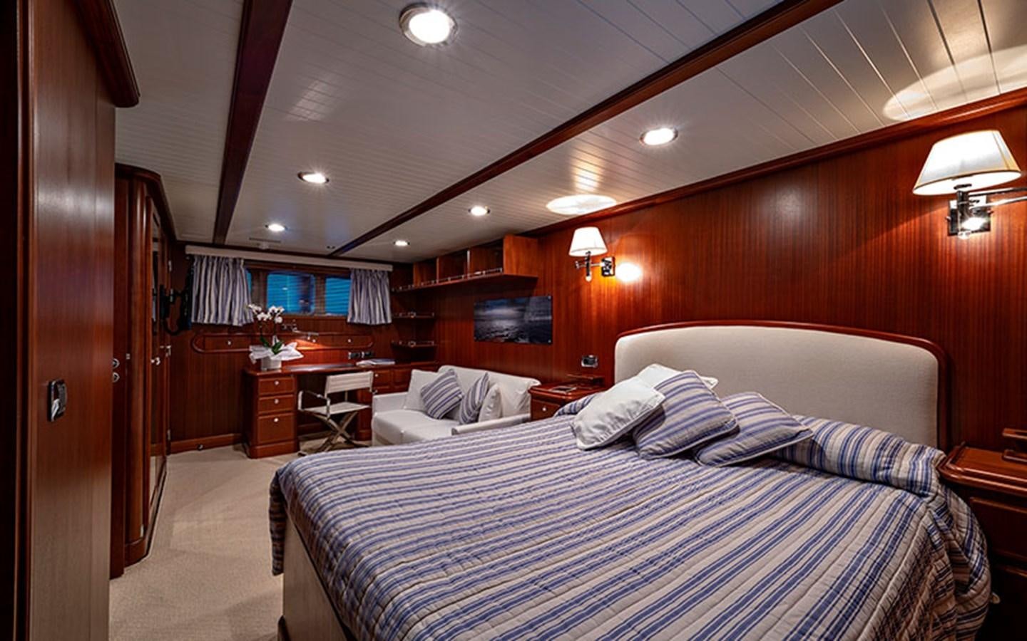 a bedroom with a bed and a desk aboard PERSUADER Yacht for Sale