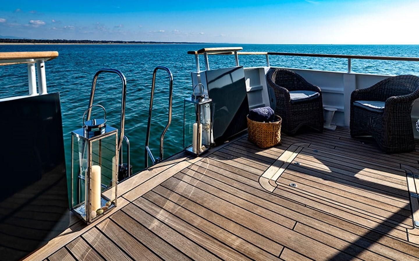 a deck with chairs and a large body of water aboard PERSUADER Yacht for Sale