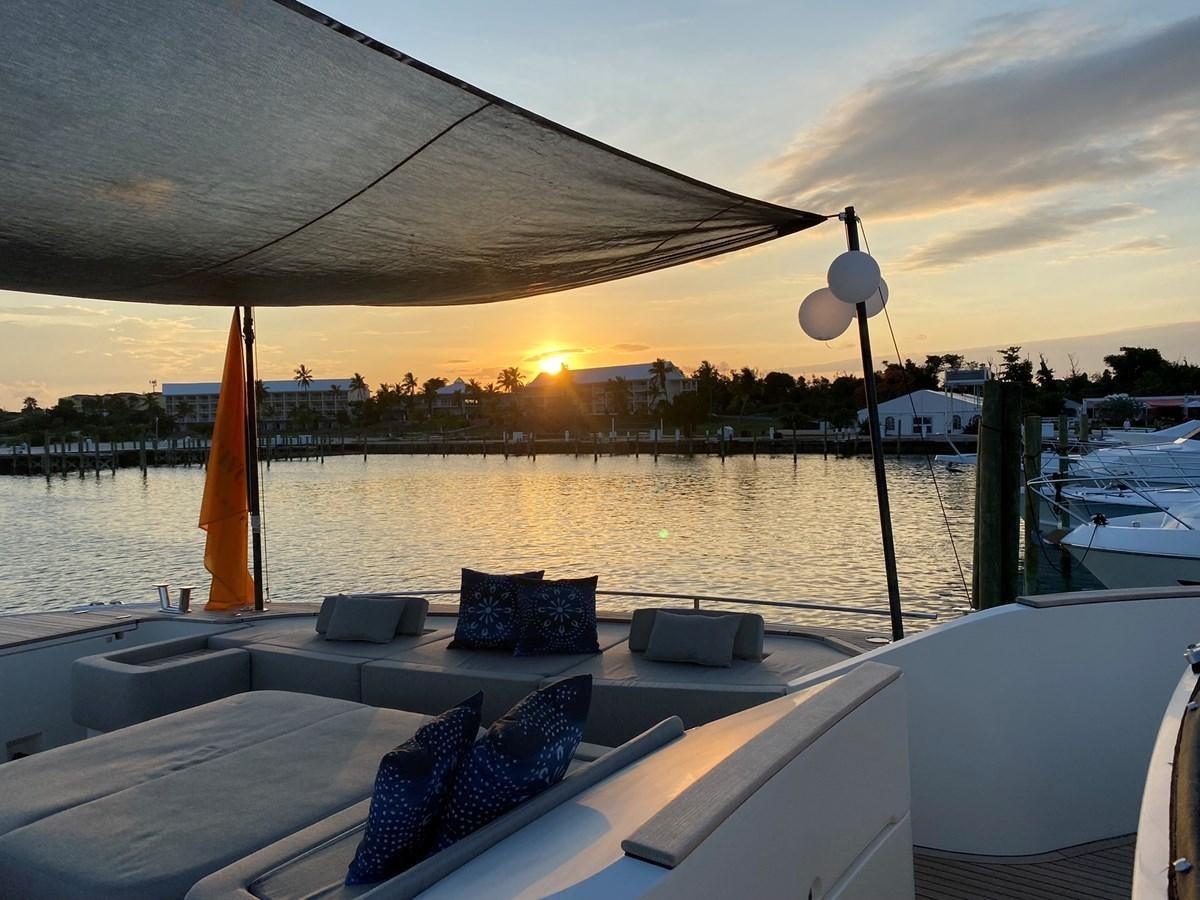 a deck with a view of a sunset and boats in the water aboard NEVER SAY NEVER 2015/2023 Yacht for Sale