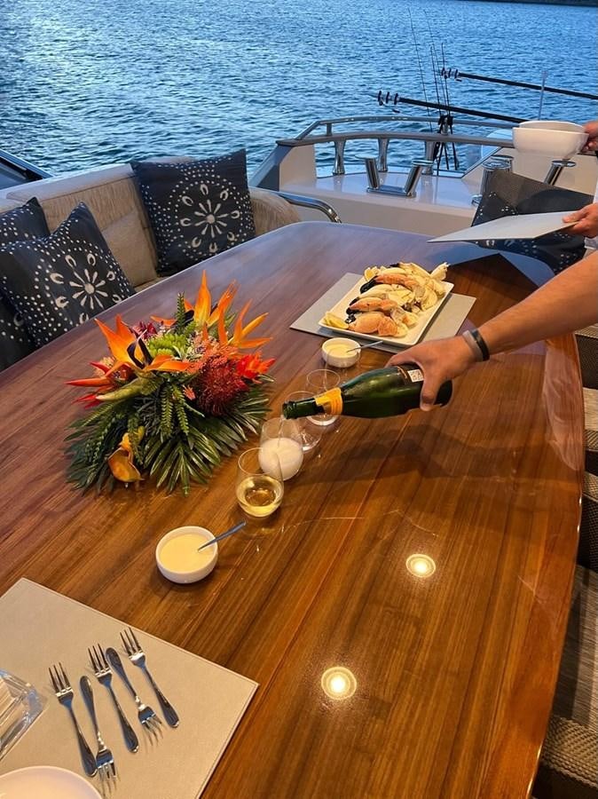 a table with food and a bottle on it aboard NEVER SAY NEVER 2015/2023 Yacht for Sale