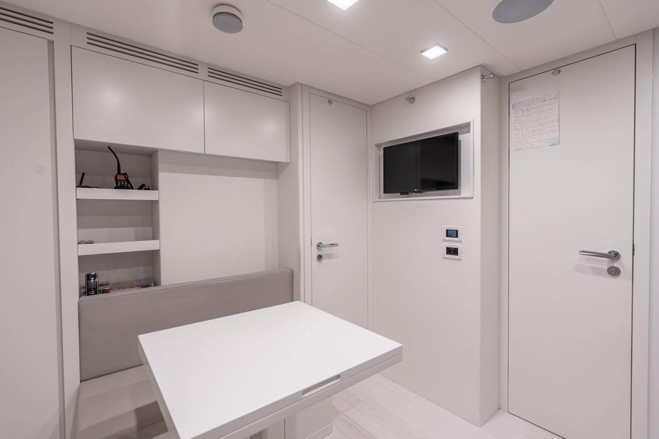 a room with a table and a tv aboard VINTAGE Yacht for Sale