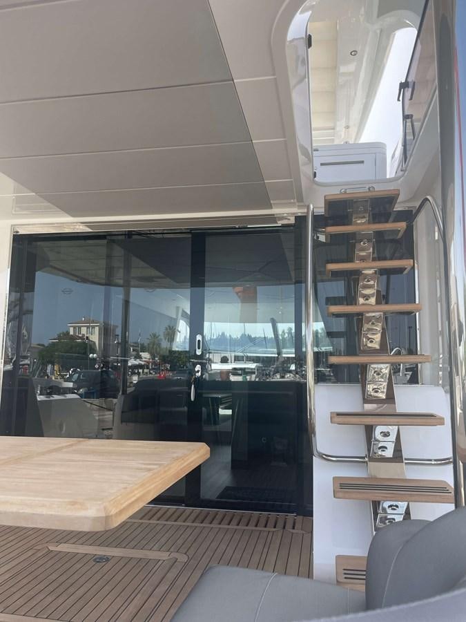 a room with a table and a shelf with books on it aboard SUNSEEKER 70' MANHATTAN Yacht for Sale