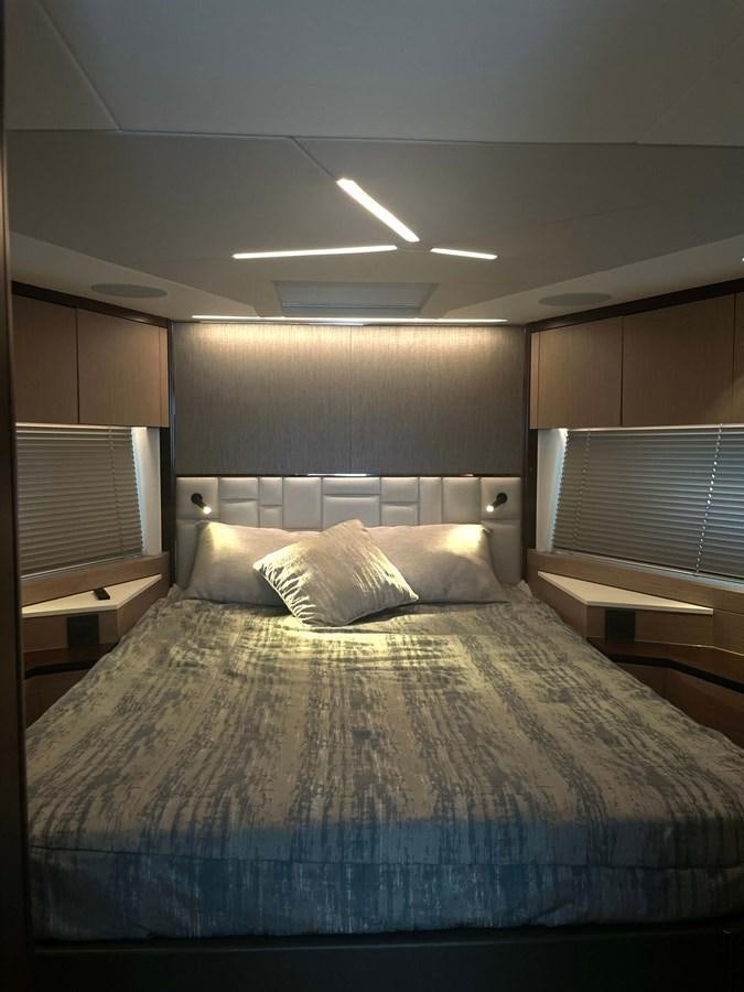 a bedroom with a bed and a window aboard SUNSEEKER 70' MANHATTAN Yacht for Sale