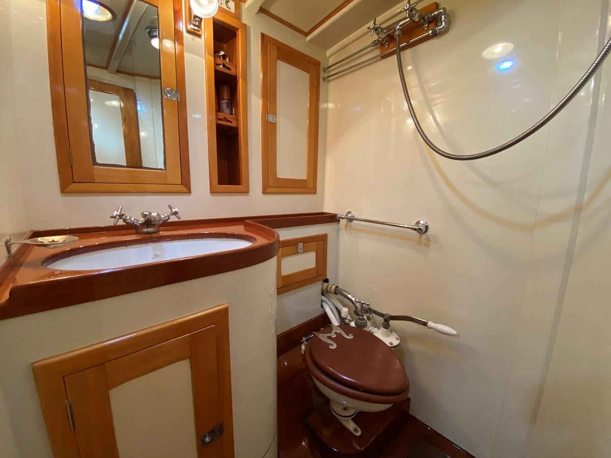 a bathroom with a toilet and sink aboard WINDIGO Yacht for Sale