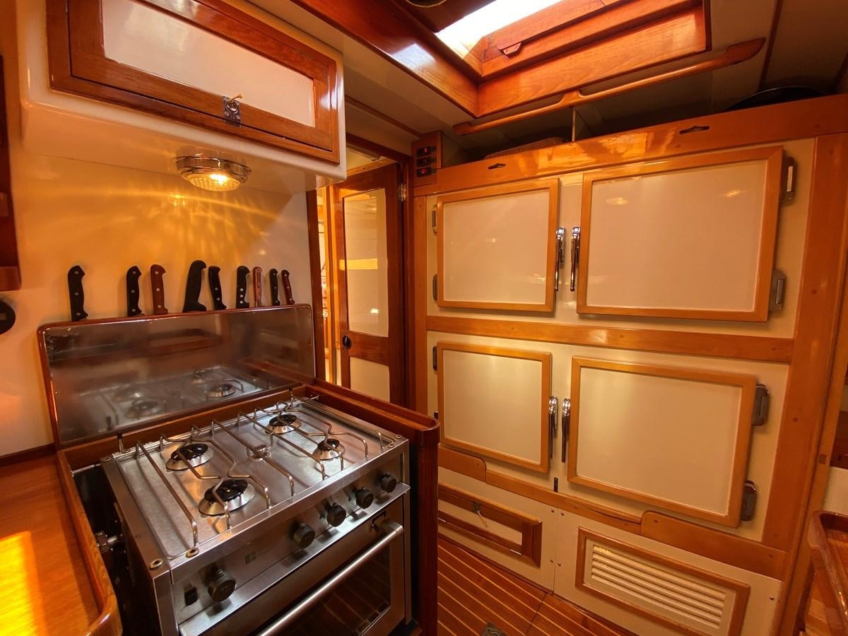 a kitchen with wooden cabinets aboard WINDIGO Yacht for Sale
