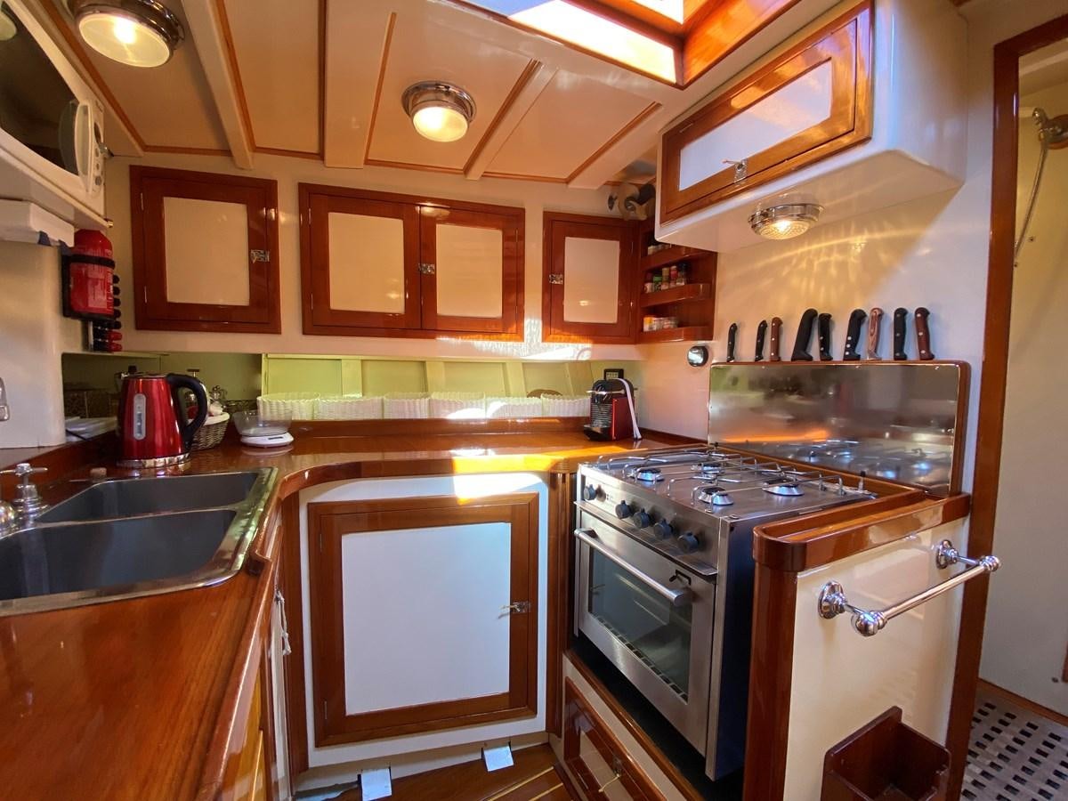 a kitchen with wooden cabinets aboard WINDIGO Yacht for Sale