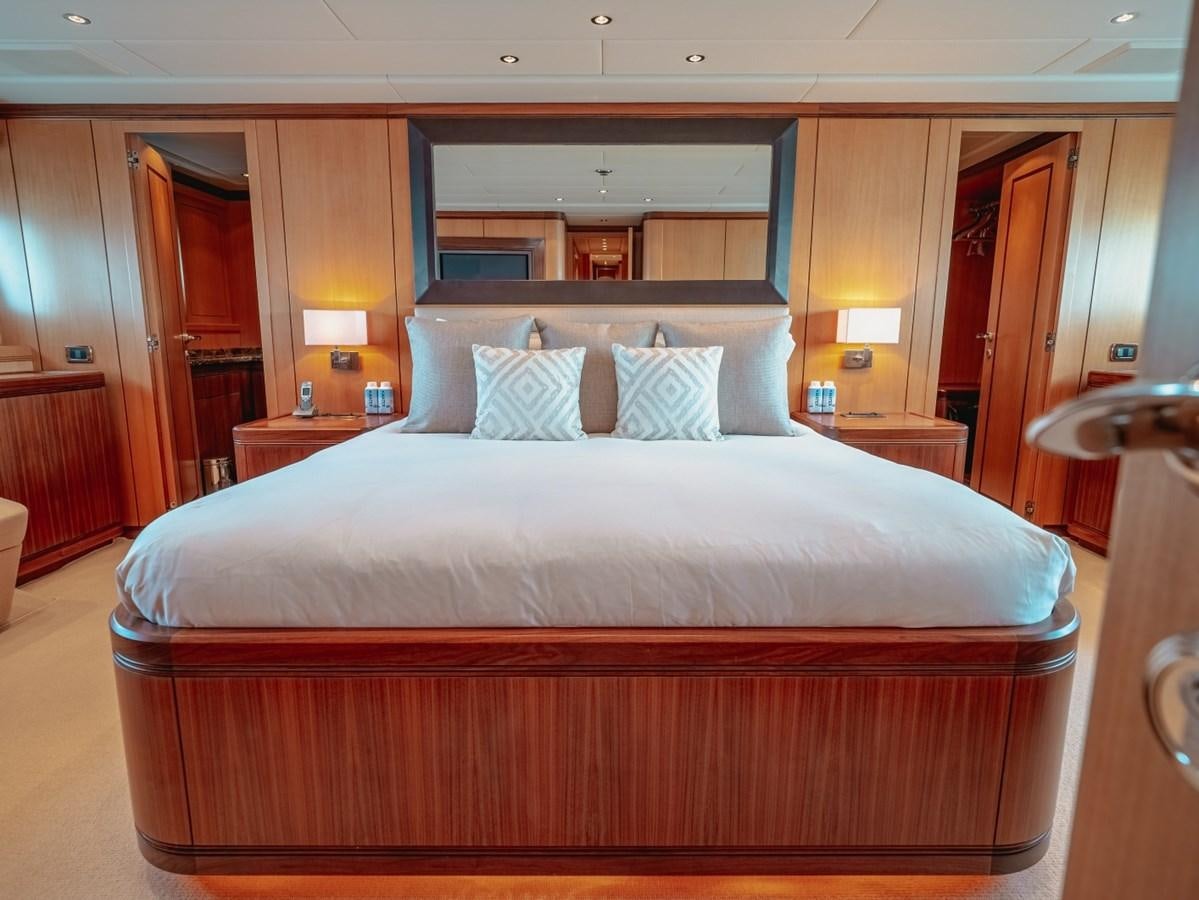 a bed with a white comforter aboard WET PANTHER Yacht for Sale
