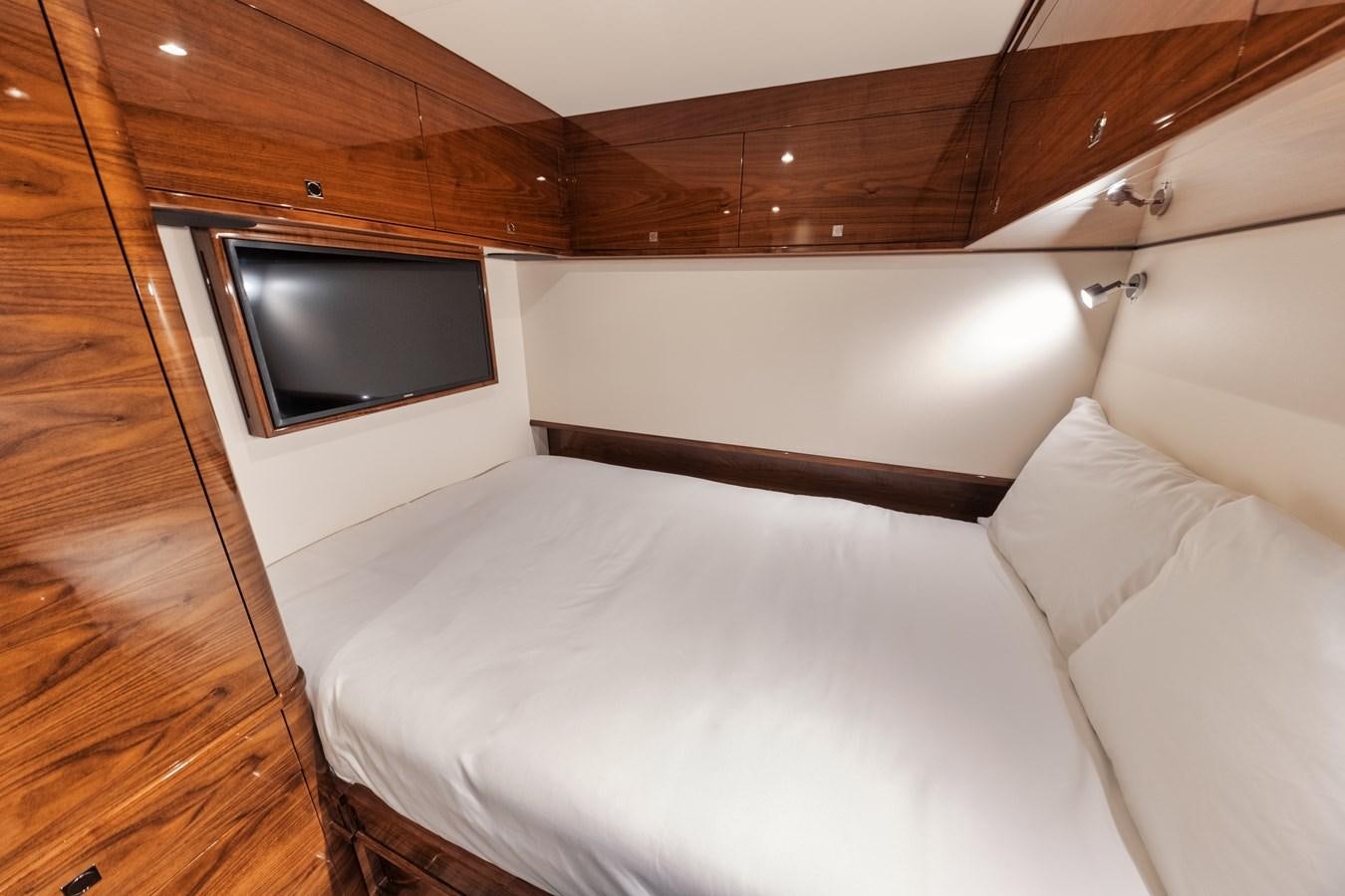 a bed with a television on the wall aboard JARUCO Yacht for Sale