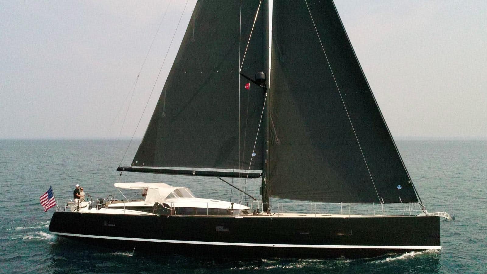 a black sailboat on the water aboard TROIS VIGNES Yacht for Sale