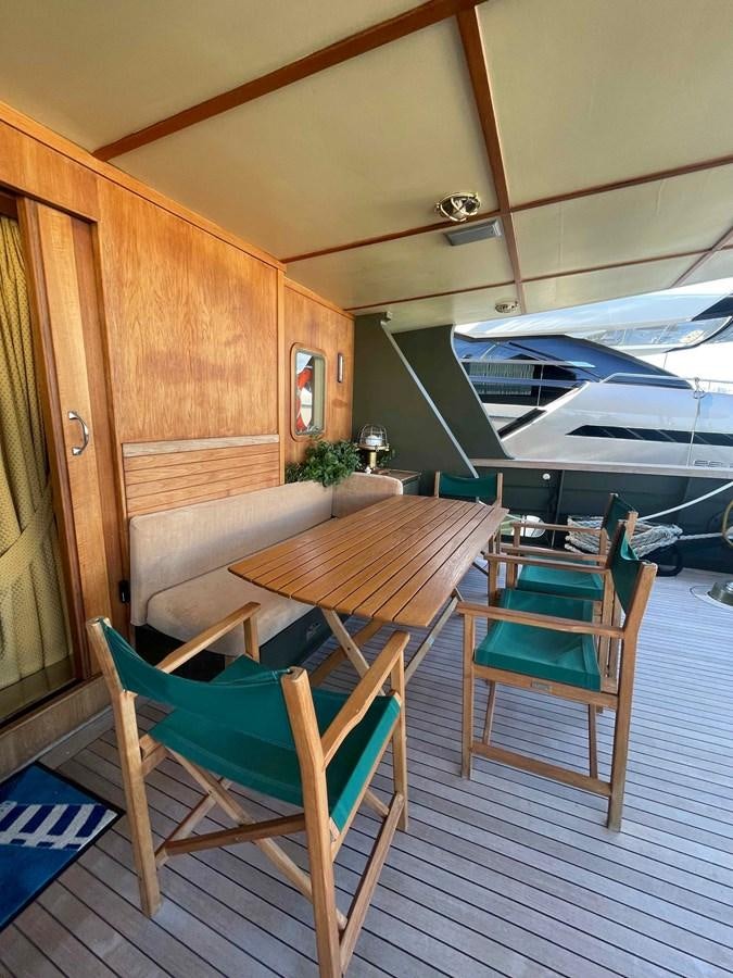 a wooden table and chairs on a deck aboard SAN GENNARO Yacht for Sale