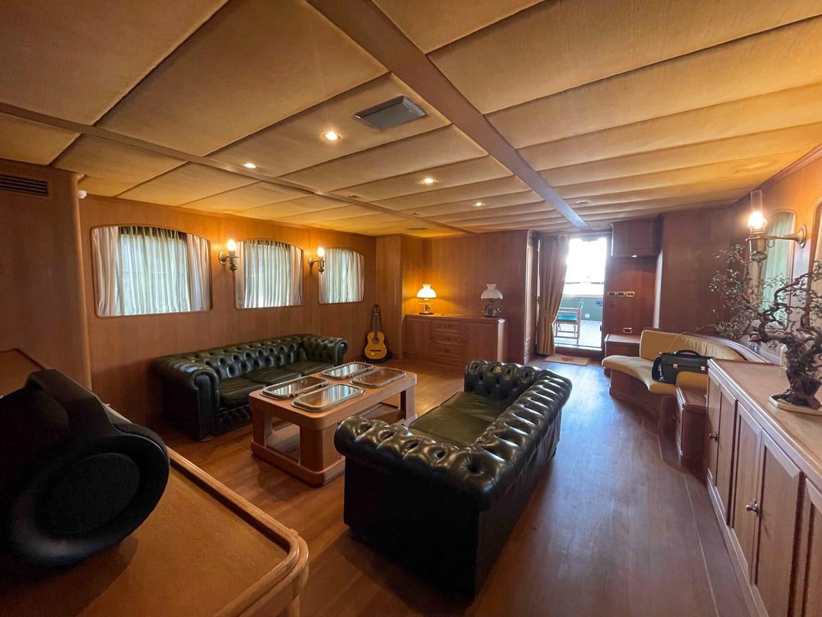 a living room with leather couches and a wood table aboard SAN GENNARO Yacht for Sale