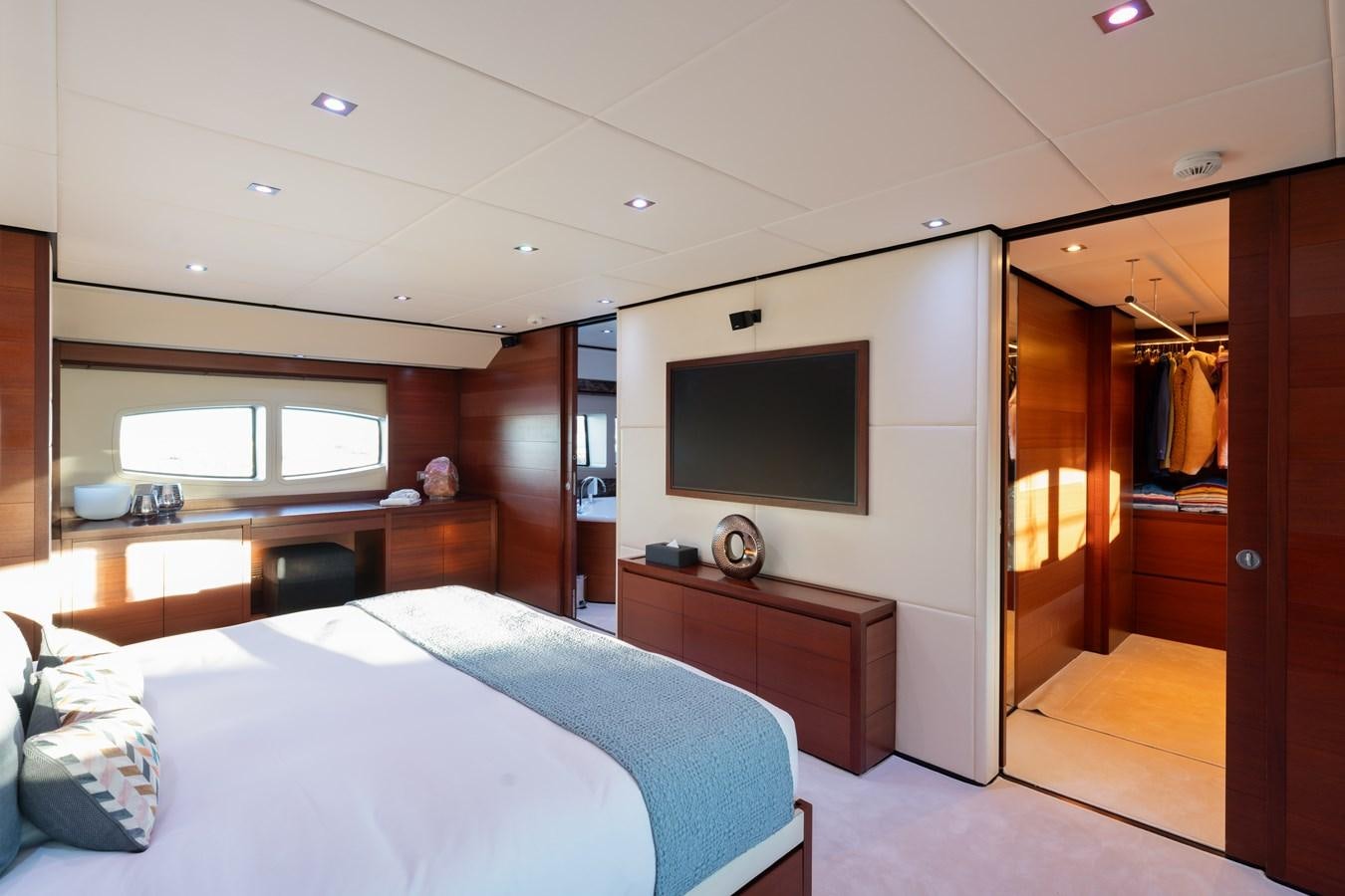 a bedroom with a bed and a tv on the wall aboard ANNAMIA Yacht for Sale