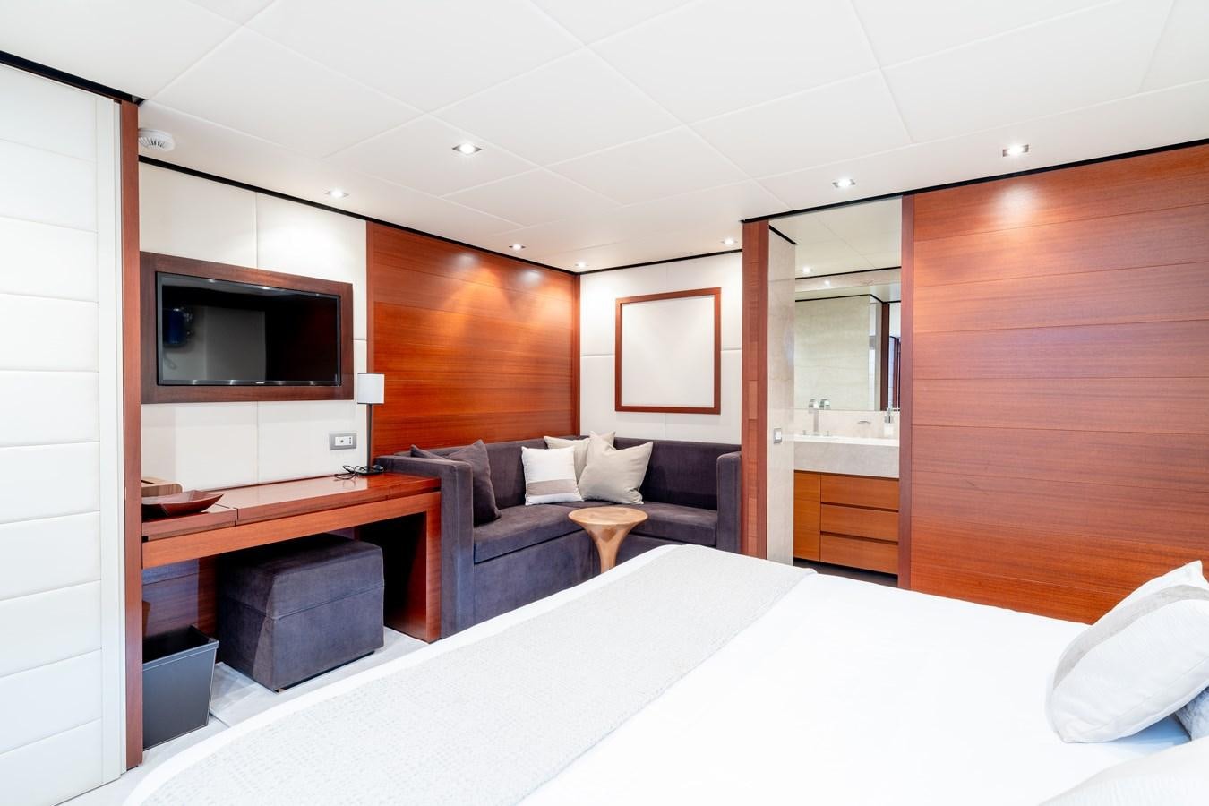 a room with a bed and a television aboard ANNAMIA Yacht for Sale