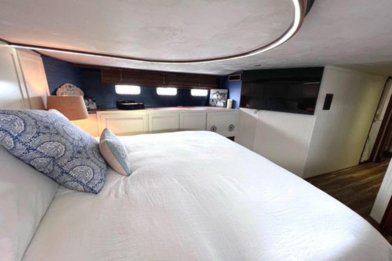 a bed with a white comforter aboard NORTHER VENTURE Yacht for Sale