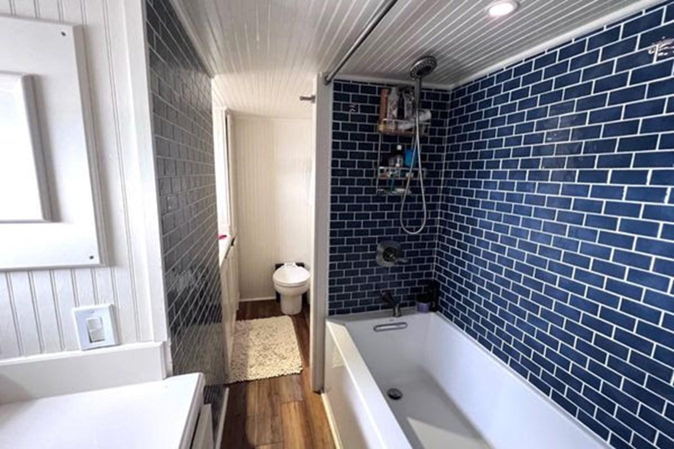 a bathroom with a tub and toilet aboard NORTHER VENTURE Yacht for Sale