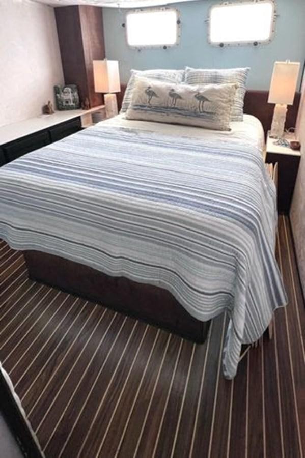 a bed with a blue comforter aboard NORTHER VENTURE Yacht for Sale