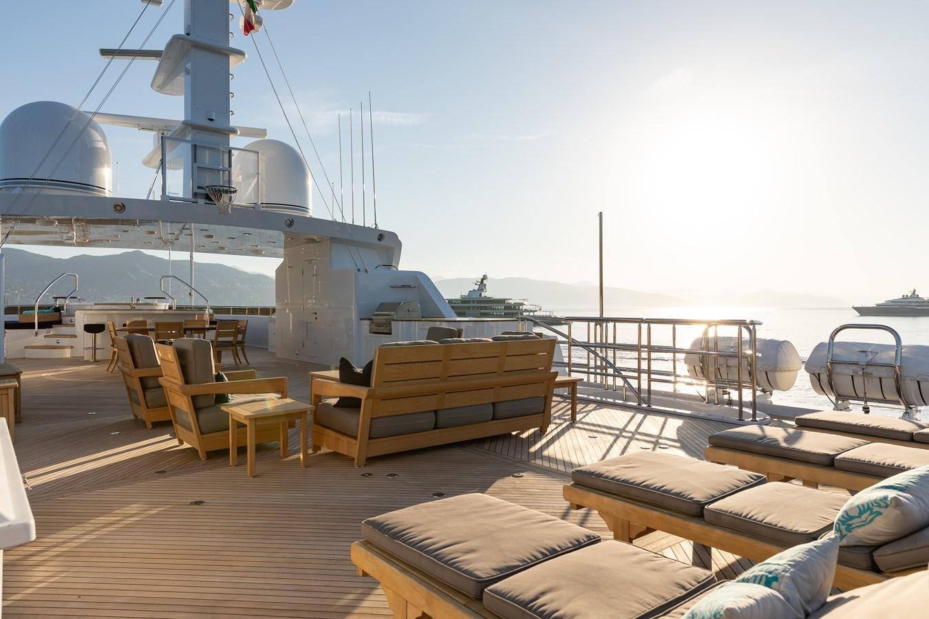 a deck with a deck chairs and a large ship in the background aboard SKYFALL Yacht for Sale