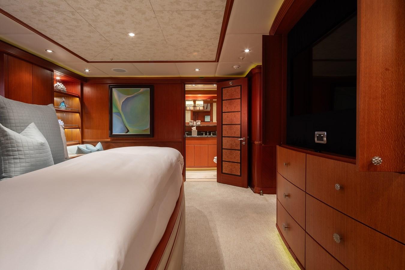 a bedroom with a bed and a tv aboard SKYFALL Yacht for Sale