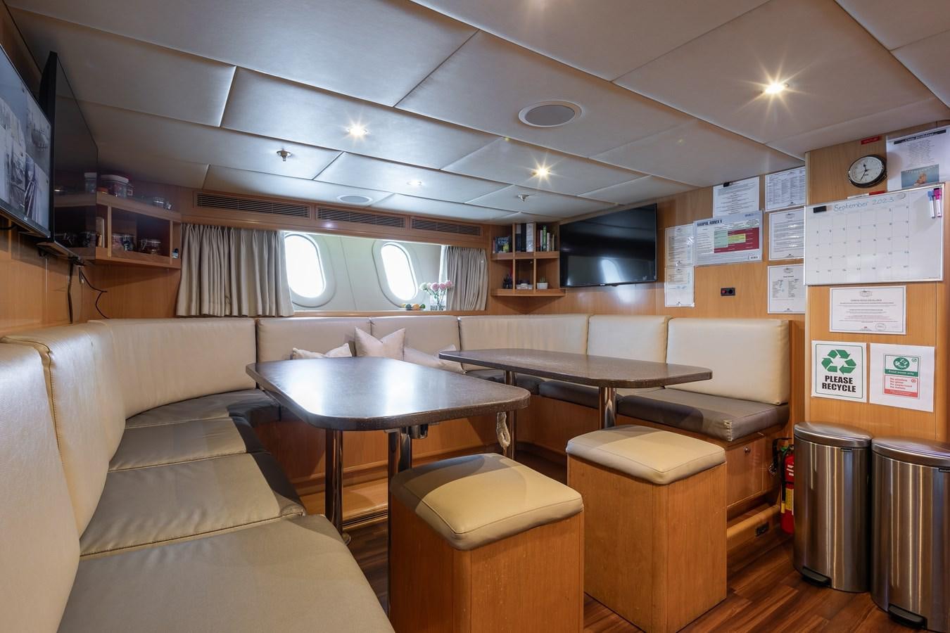 a room with a table and couch aboard SKYFALL Yacht for Sale