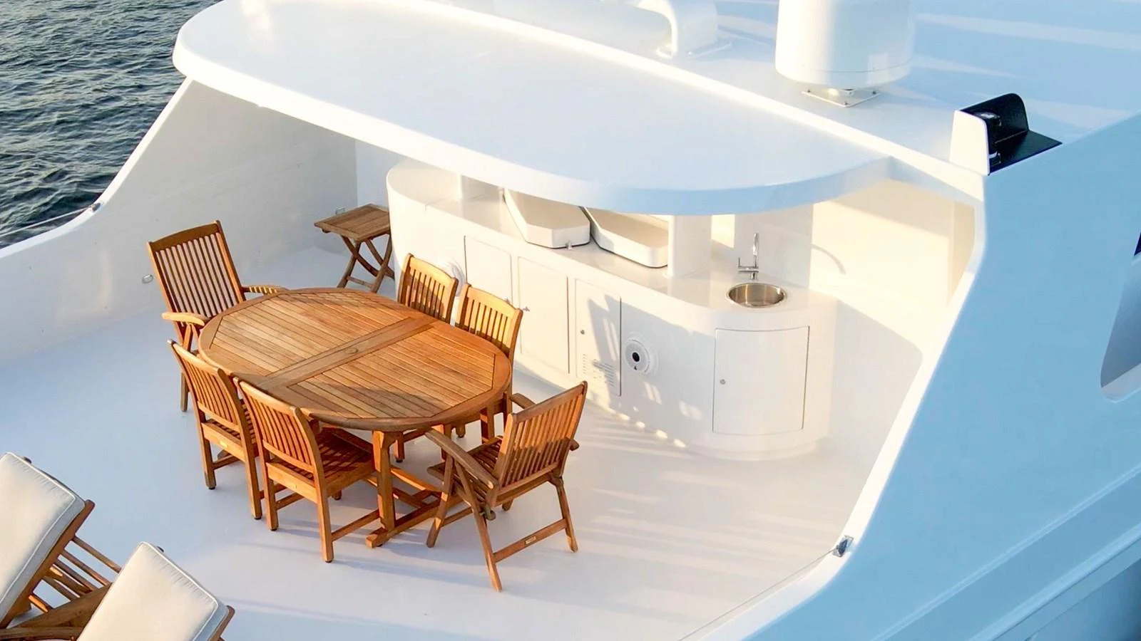 a white boat with a table and chairs on it aboard DOZER Yacht for Sale