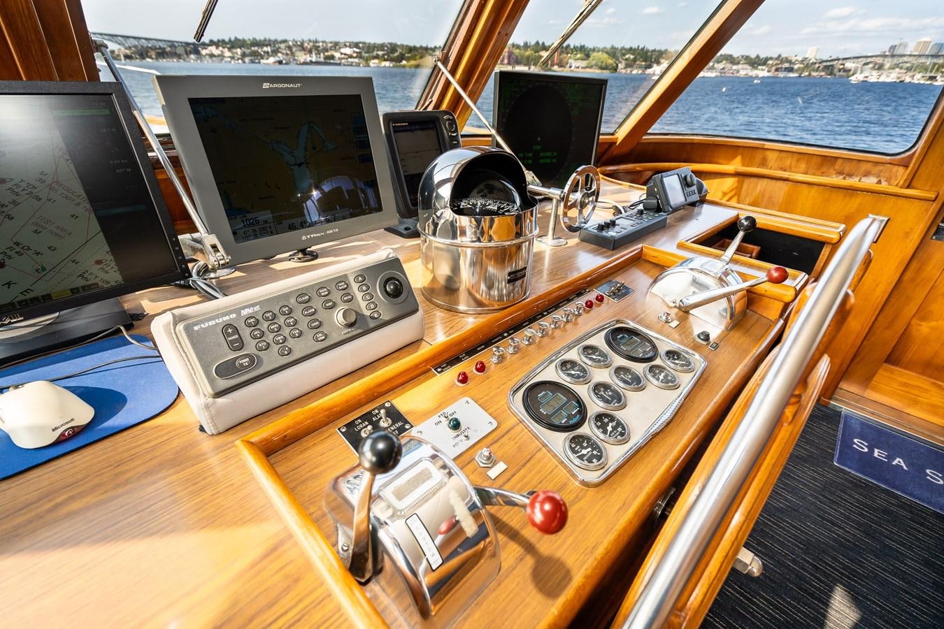 a wooden desk with a computer and other electronics on it aboard SEA STAR Yacht for Sale
